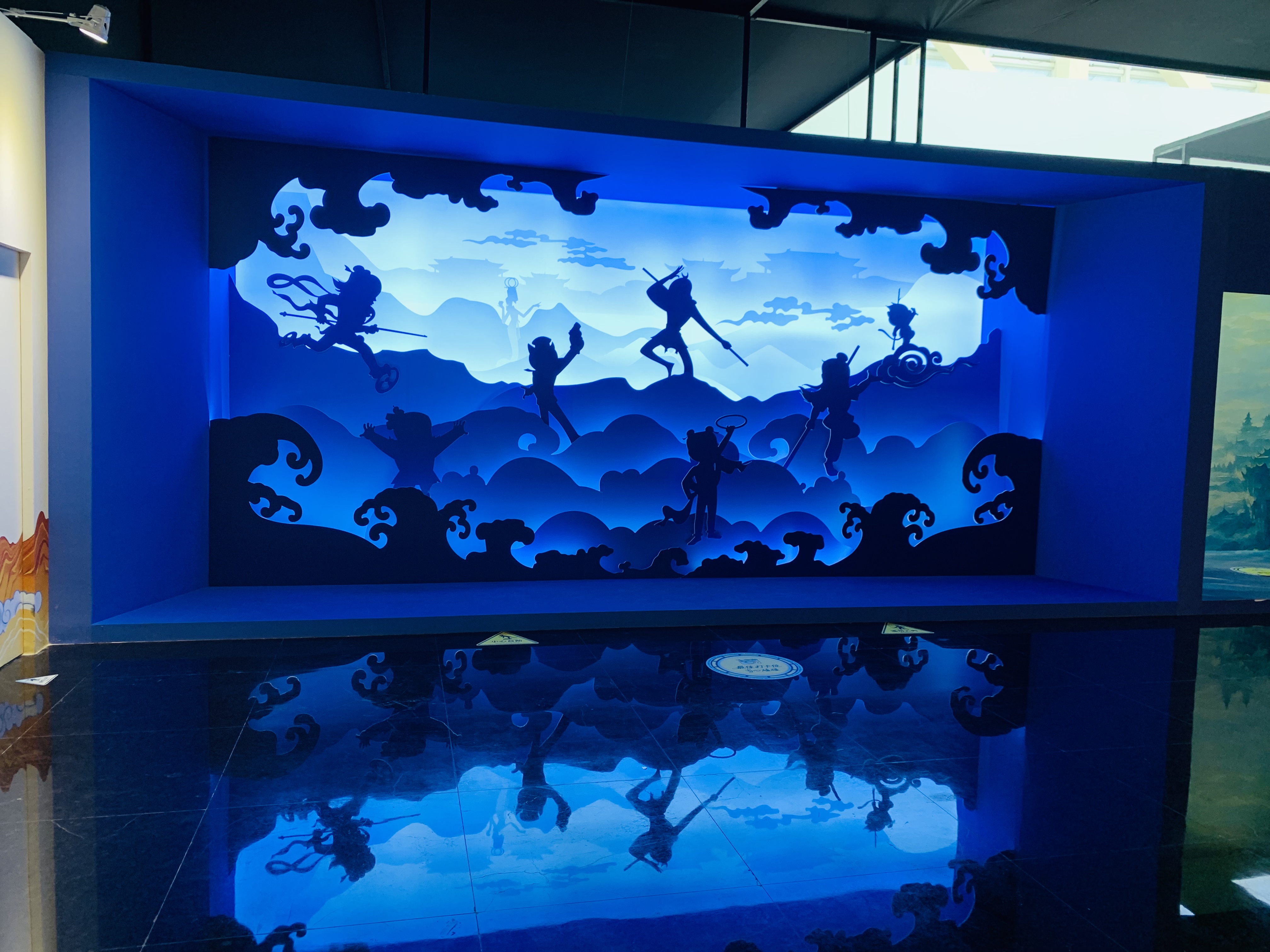 Blue illuminated silhouettes of classic Chinese animated characters at an animation exhibition.